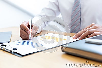 Businessmen use graphs to summarize results and calculate income-expenses to find financial balance points and use them to improve Stock Photo