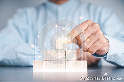Businessmen use a handle on the wooden block to show stock graphs and rising stock signals with chart indicators. Concepts of Stock Photo