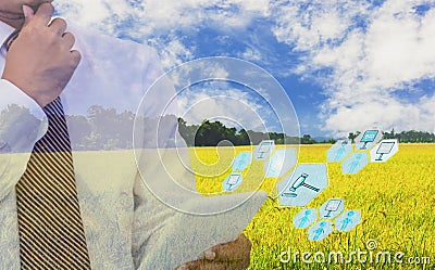 Businessmen use tablet to participate in auction, with icon of agricultural product auctioneer, sky background and organic fields, Stock Photo