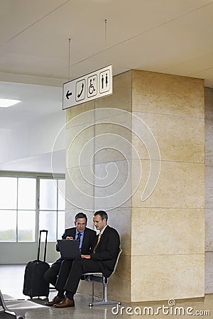 Businessmen Using Laptop In Airport Stock Photo