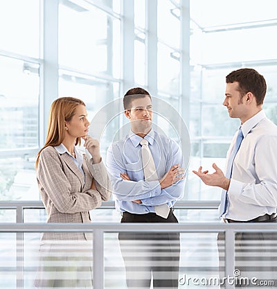 Businesspeople chatting in modern office lobby Stock Photo