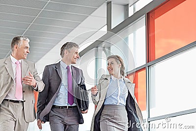 Businesspeople communicating while walking on railroad platform Stock Photo