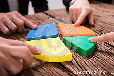 Businesspeople Connecting Pieces Of Pie Chart Stock Photo