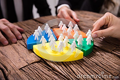 Businesspeople Connecting Pieces Of Pie Chart With Human Figures Stock Photo