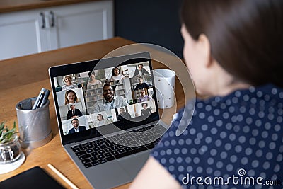 Businesspeople engaged in videoconference, laptop screen over female shoulder Stock Photo
