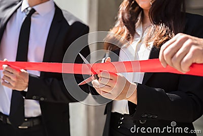 Businesspeople Hand Cutting Red Ribbon Stock Photo