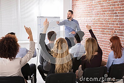 Group Of Businesspeople Raising Hands In Conference Stock Photo