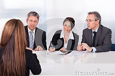 Businesspeople interviewing woman Stock Photo