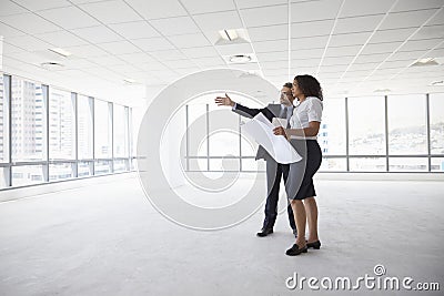 Businesspeople Meeting To Look At Plans In Empty Office Stock Photo