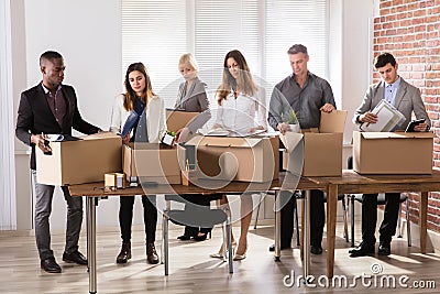 Businesspeople Packing Belongings In Cardboard Box Stock Photo