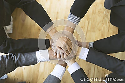 Businesspeople put their hand on top of each other - teamwork, u Stock Photo