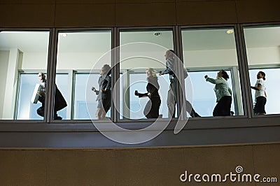 Businesspeople Running Down Hallway Stock Photo