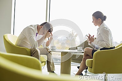 Businesspeople in serious discussion at office lobby Stock Photo