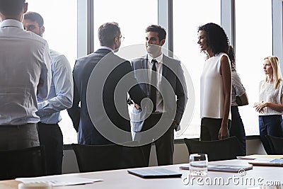 Businesspeople Shaking Hands Before Meeting In Boardroom Stock Photo