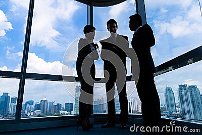 Businesspeople standing at office windo working Stock Photo