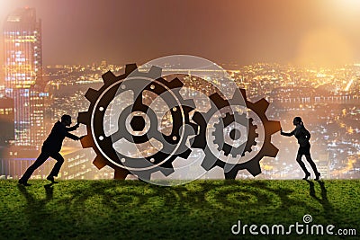 The businesspeople in teamwork example with cogwheels Stock Photo