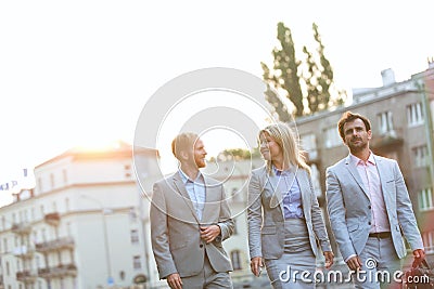 Businesspeople walking in city on sunny day Stock Photo