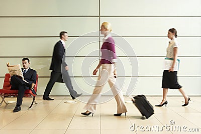 Businesspeople Walking In Office Corridor Stock Photo
