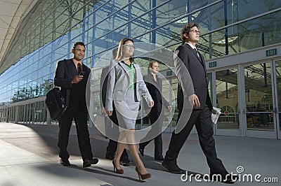 Businesspeople Walking Past Office Building Stock Photo