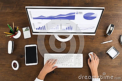 Businessperson Analyzing Statistical Graph On Computer Stock Photo