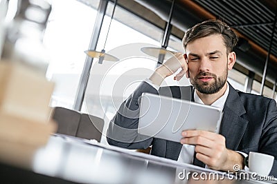 Businessperson on business lunch at restaurant sitting drinking espresso watching video on digital tablet Stock Photo