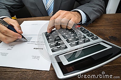 Businessperson calculating financial sheet Stock Photo