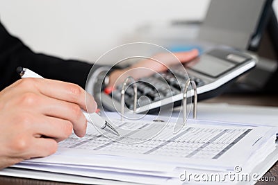 Businessperson Calculating Invoice In Office Stock Photo