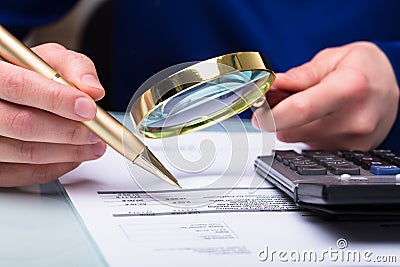 Businessperson Checking Bill Through Magnifying Glass Stock Photo