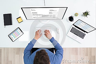 Businessperson Checking Invoice On Computer Stock Photo