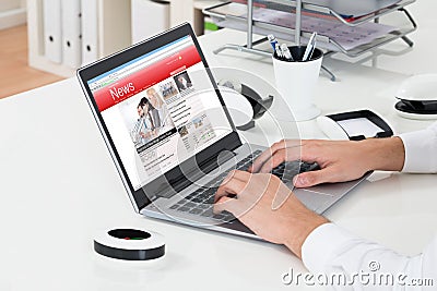 Businessperson Checking Online News On Laptop Stock Photo