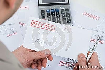 Businessperson hand with past due envelope Stock Photo