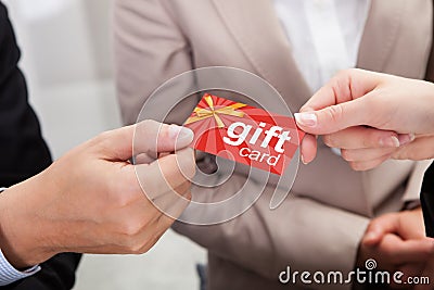 Businessperson Hands Giving Gift Card To Other Businessperson Stock Photo