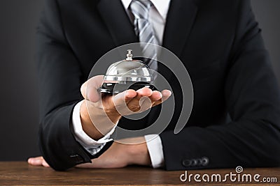 Businessperson Hands Holding Service Bell Stock Photo