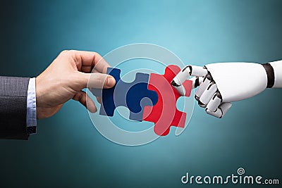 Businessperson And Robot Holding Jigsaw Puzzle Stock Photo