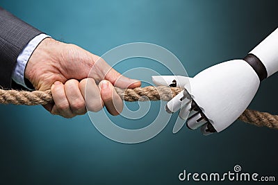 Businessperson And Robot Playing Tug Of War Stock Photo