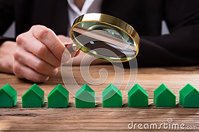 Businessperson Holding Magnifying Glass Over House Model Editorial Stock Photo