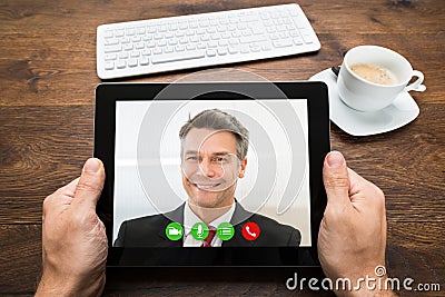 Businessperson Video Chatting With Colleague Stock Photo