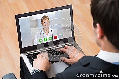 Businessperson Videochatting Online With Doctor On Laptop Stock Photo
