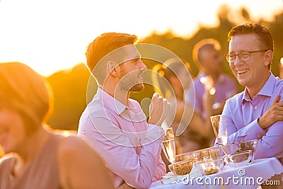 Businesss colleagues standing while talking on table at rooftop Stock Photo