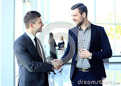 Businesss and office concept - two businessmen shaking hands Stock Photo