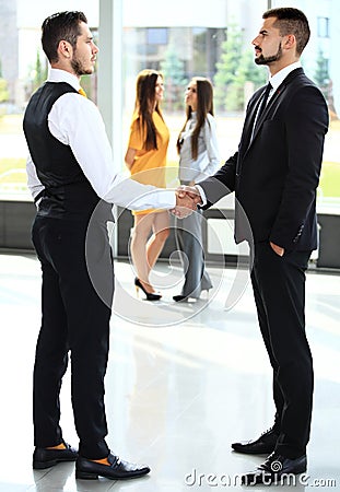 Businesss and office concept - two businessmen shaking hands Stock Photo