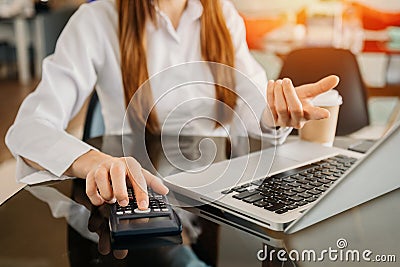 Businesswoman or accountant hand typing laptop working to calculate on desk about cost at home office Stock Photo