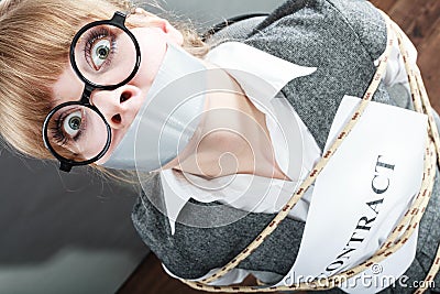 Businesswoman bound by contract with taped mouth. Stock Photo