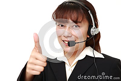Businesswoman of call center with thumbs up gesture Stock Photo