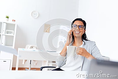 Businesswoman calling on smartphone at office Stock Photo