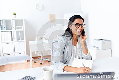 Businesswoman calling on smartphone at office Stock Photo