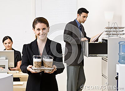 Businesswoman carrying tray of coffee Stock Photo