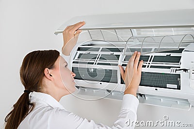 Businesswoman Checking Air Conditioner Stock Photo