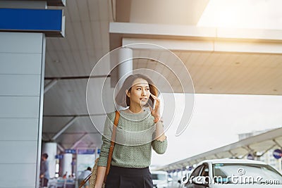 Businesswoman on commute transit talking on the smartphone while walking with hand luggage in train station or airpot going to Stock Photo