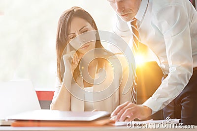 Businesswoman concentrating while colleague explaining at desk Stock Photo